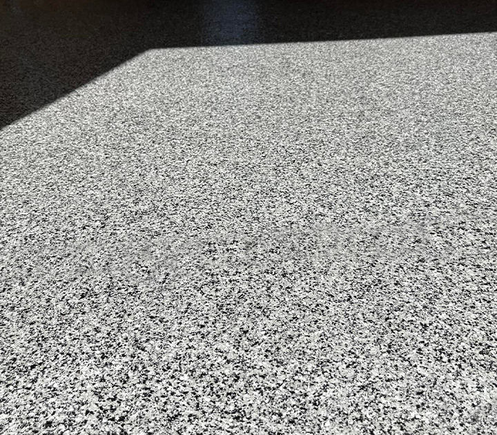 This is a close up of the decorative flake epoxy floor patten and flake installed by J&A Services.